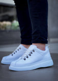 White sneakers worn with dark jeans on a blurred background