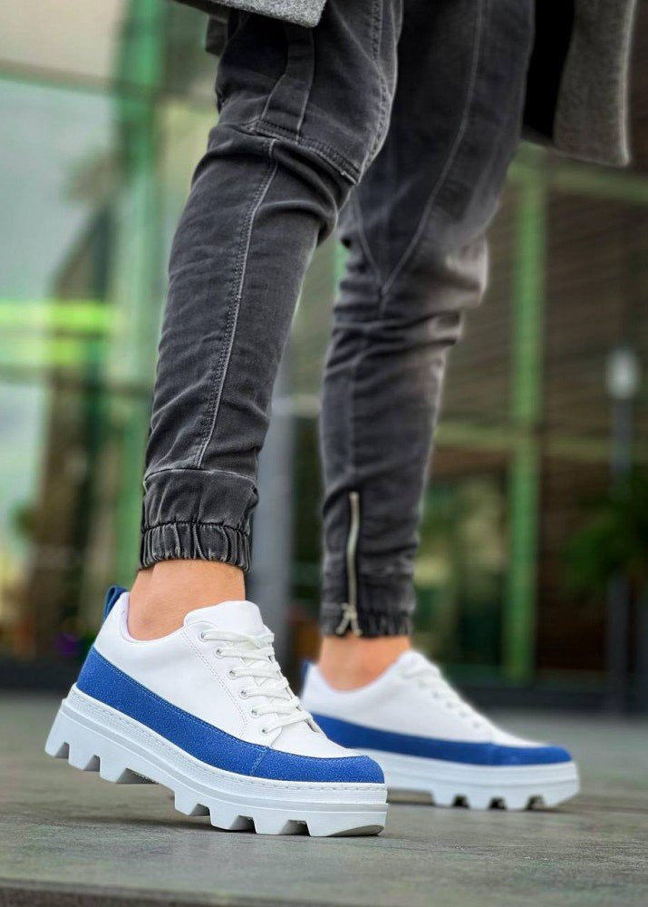 White sneakers with blue accents worn by a person on a blurred background