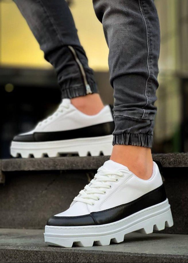 White and black sneakers worn on a step