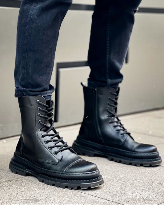 Lifestyle shot of Orion Black Combat Boots by Apollo Moda in polished leather with rugged soles and zip detail worn outdoors.