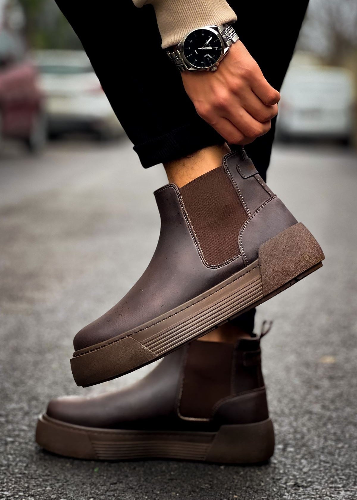 Close-up of Avalon Coffee Brown Chelsea boots worn outdoors on wet pavement.