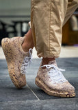 Man wearing Torino Light Brown Peak sneakers with hand-painted splatter design and white laces.