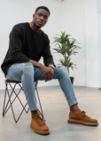 Man sitting on a chair wearing brown shoes Apollo Moda Torino breathable sneakers with chunky soles