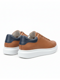 Brown and navy sneakers on a white background